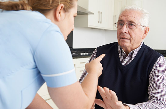 Carer pointing threateningly at old man